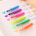 Six syringe-shaped fluorescent highlighter pens in assorted colours on a white background