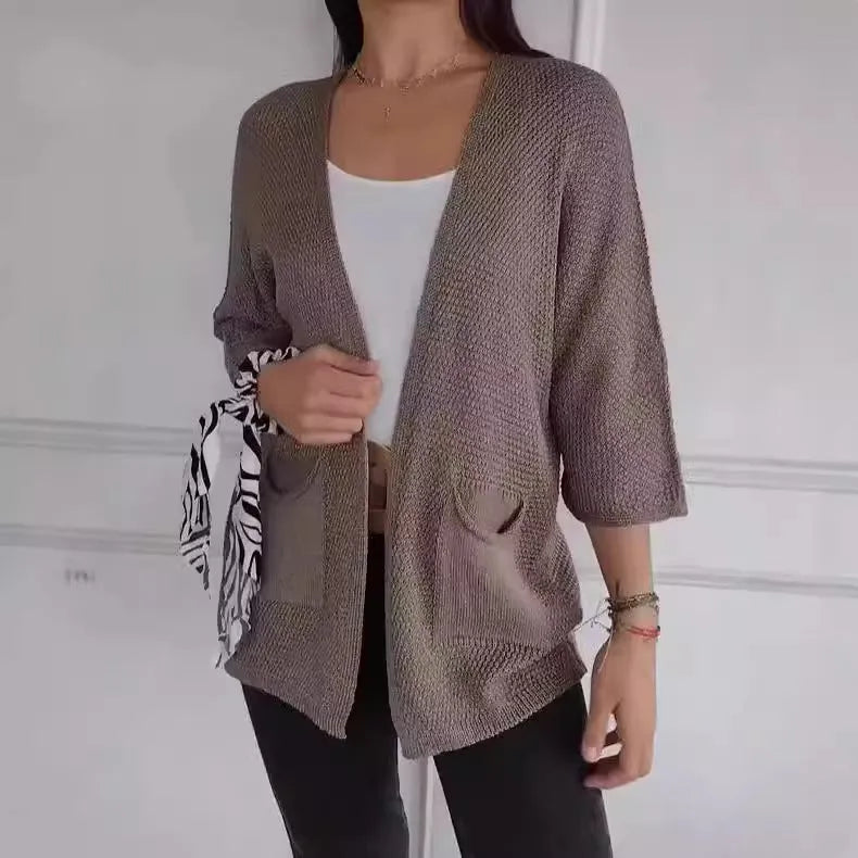 Women's waffle-knit cardigan coat in army green, showing texture and pocket detail.