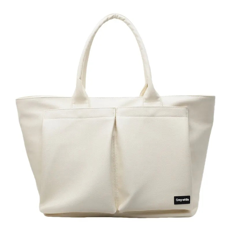 Lightweight solid colour PU shoulder bag shown in black, featuring an expandable design.