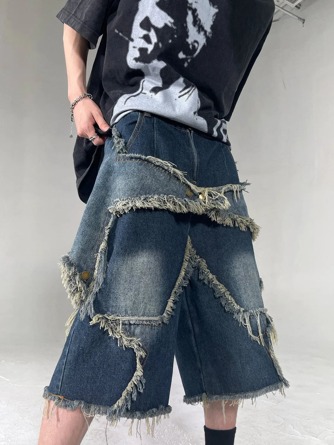 Blue denim shorts with frayed detailing and five-pointed star design in loose fit style