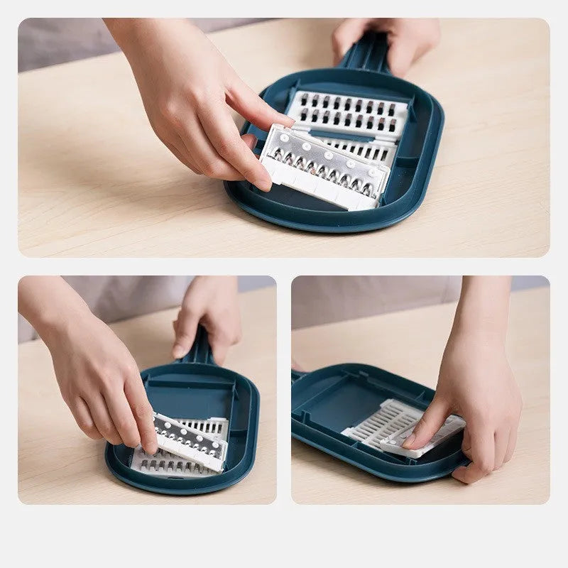 Dark blue manual vegetable cutter with four stainless steel blades, a hand protection guard, and a drain basket on a kitchen counter.