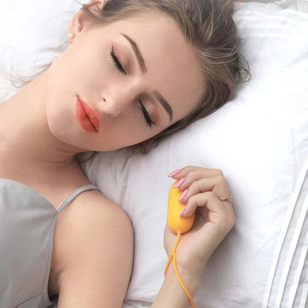 Handheld micro-current sleep aid device in grey, green, or orange colour with USB charging cable.
