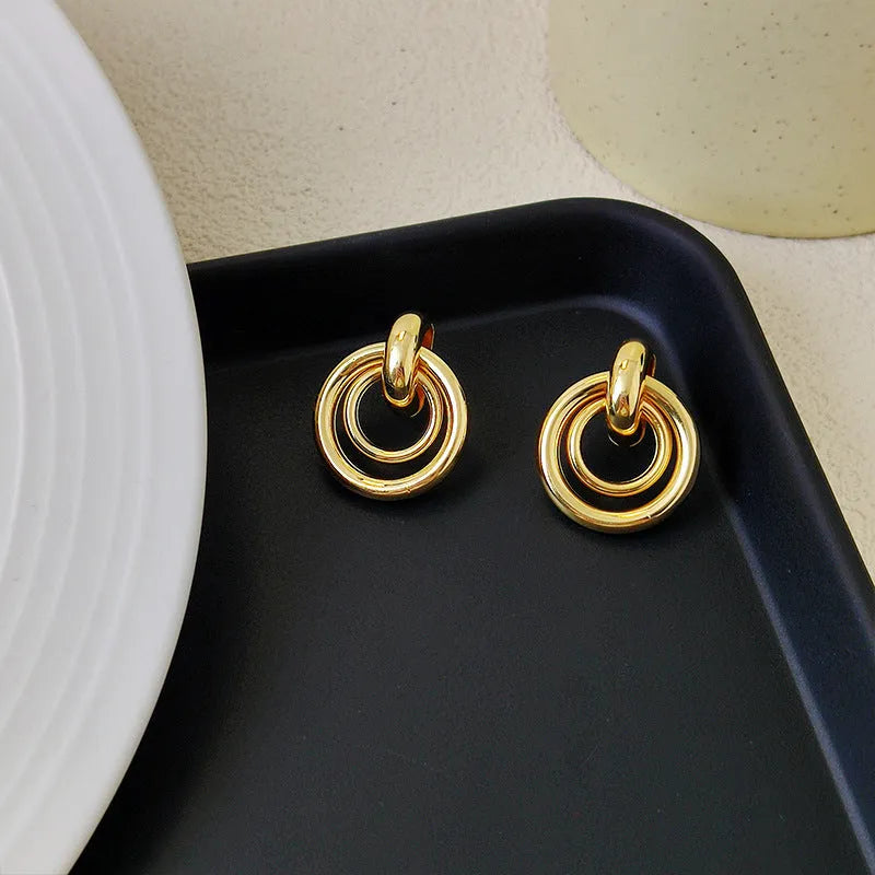 Geometric irregular round ring earrings in electroplated gold colour with exotic style mixed material construction