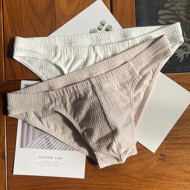Men's solid colour pure cotton triangle underwear briefs on a mid waist, shown in apricot and black colour options.