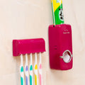 White bathroom accessories set with toothpaste dispenser and toothbrush holder mounted on smooth tile surface