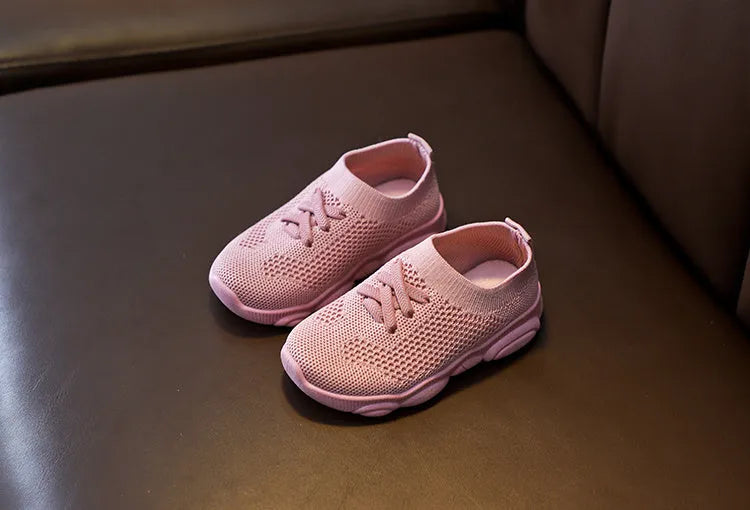 Children's white fabric lazy shoe with a non-slip rubber sole, shown on a foot.