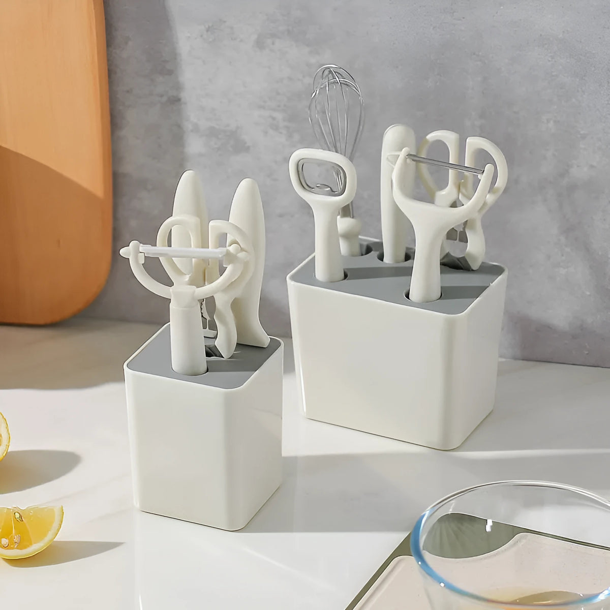 Six-piece white stainless steel kitchen gadget set arranged on a neutral background