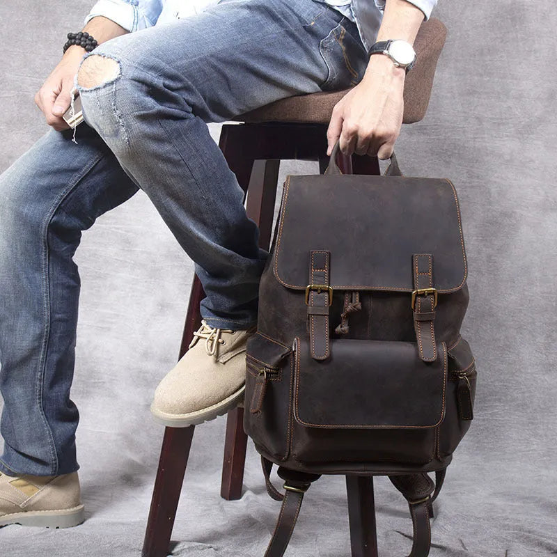 Brown genuine cowhide leather backpack with double shoulder straps and a soft handle.