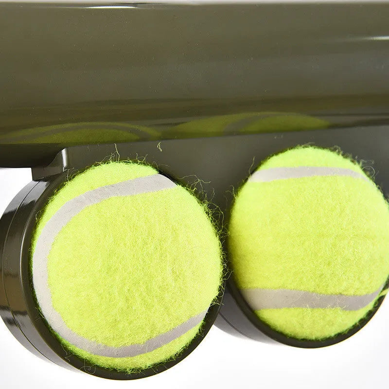 Black ABS plastic tennis ball launcher for dogs with a tennis ball ready to launch.