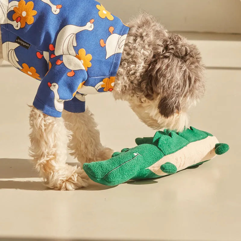 Green plush stuffed toy dog on white background, showing soft texture and size.