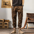 Men's khaki cotton harem pants with tapered ankle cuffs and a loose fit, shown laid flat.