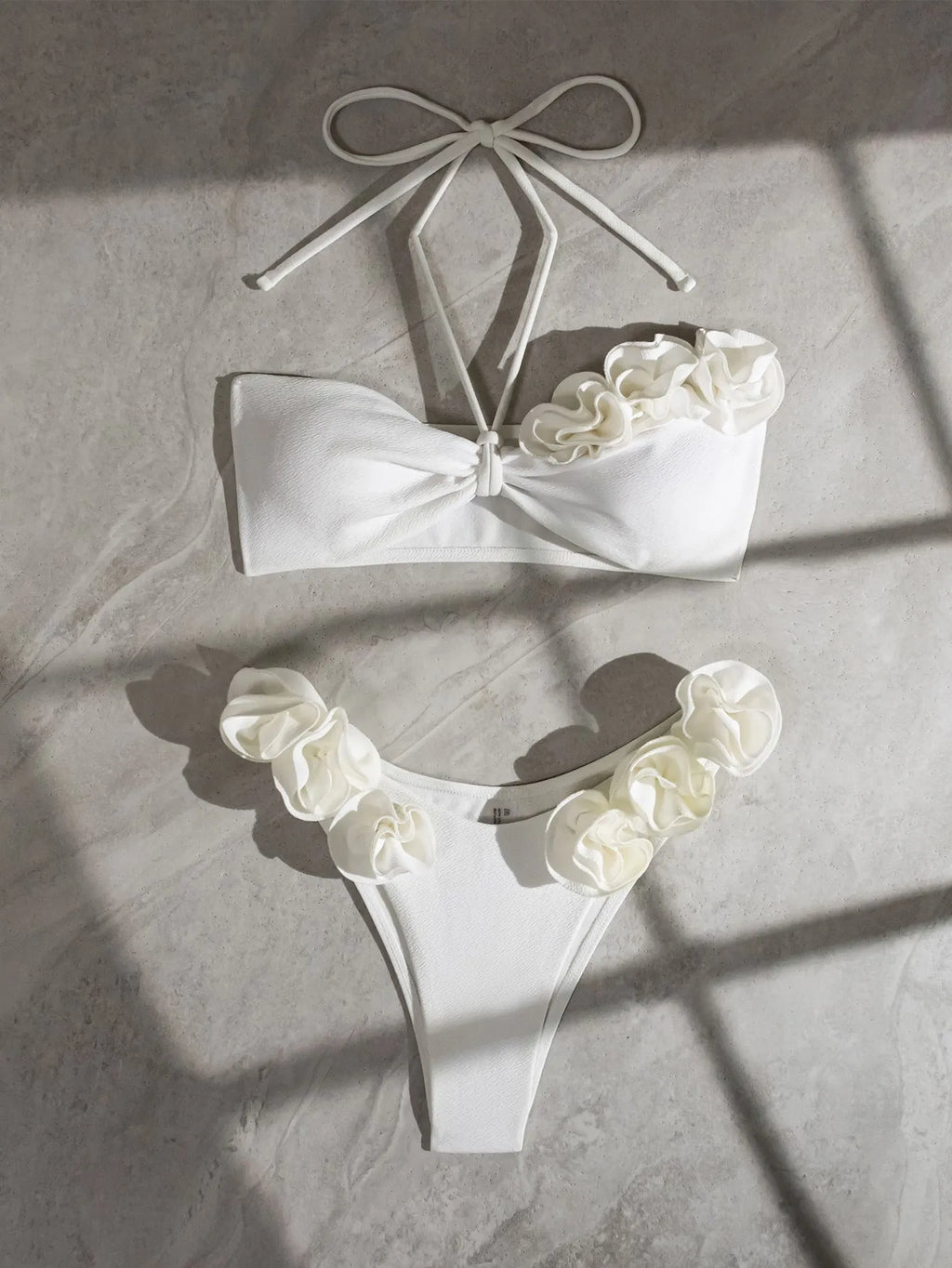 White women's halter lace-up swimsuit with three-dimensional floral design and briefs