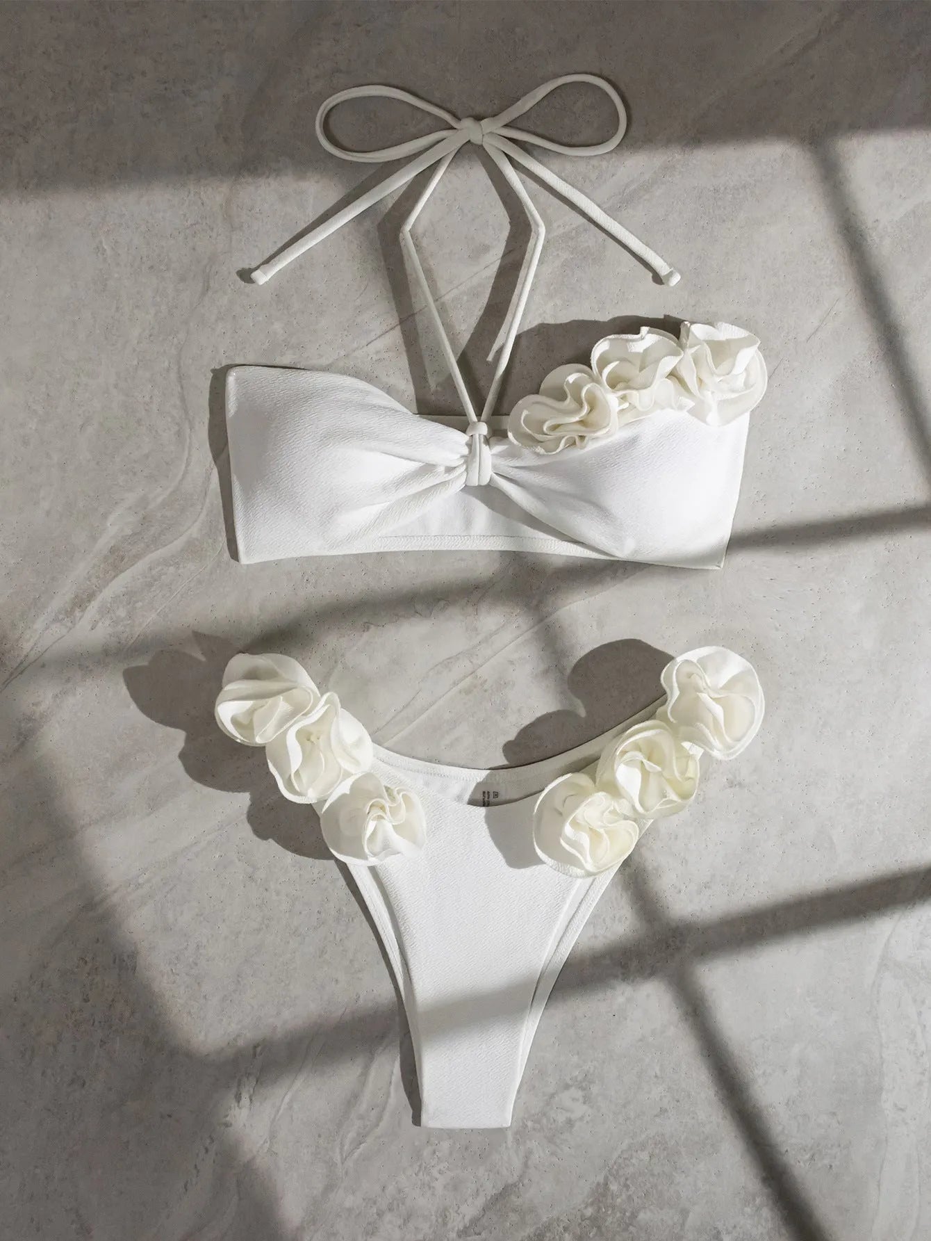 White women's halter lace-up swimsuit with three-dimensional floral design and briefs