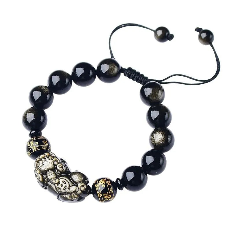 Golden obsidian bead Pi Xiu bracelet with hand-woven design on a wrist.