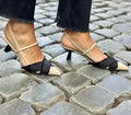 Apricot and black women's pointed toe stiletto heel sandals with a buckle strap.