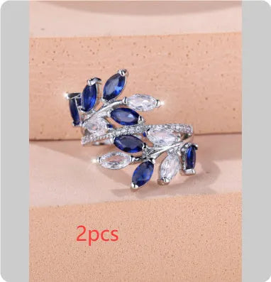 Adjustable copper leaf ring with a horse eye zircon stone in multiple colour finishes on a neutral background.