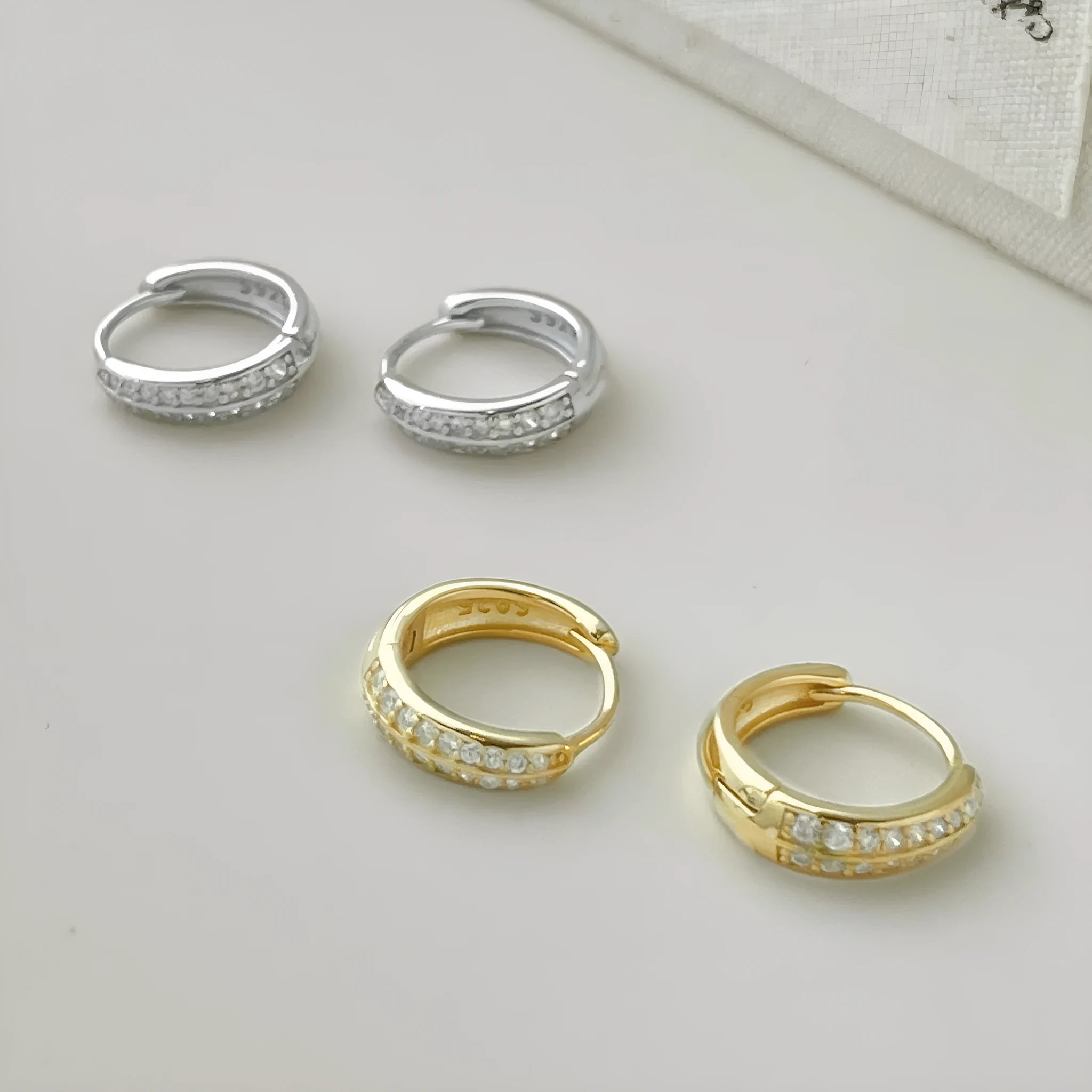 Round zircon gang drill stud earrings in 925 silver with gold electroplated finish on white background