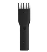 Black cordless hair clipper with a sliding length adjustment comb on a white background.