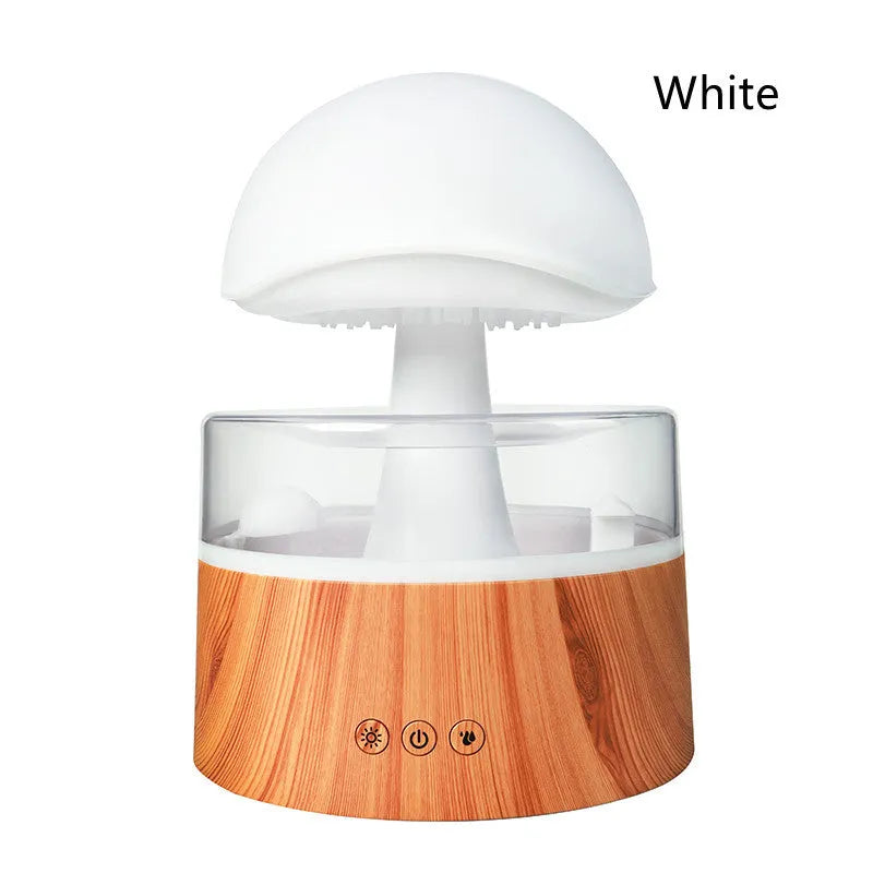 White cloud-shaped humidifier with simulated raindrops and colour-changing lights on wooden surface