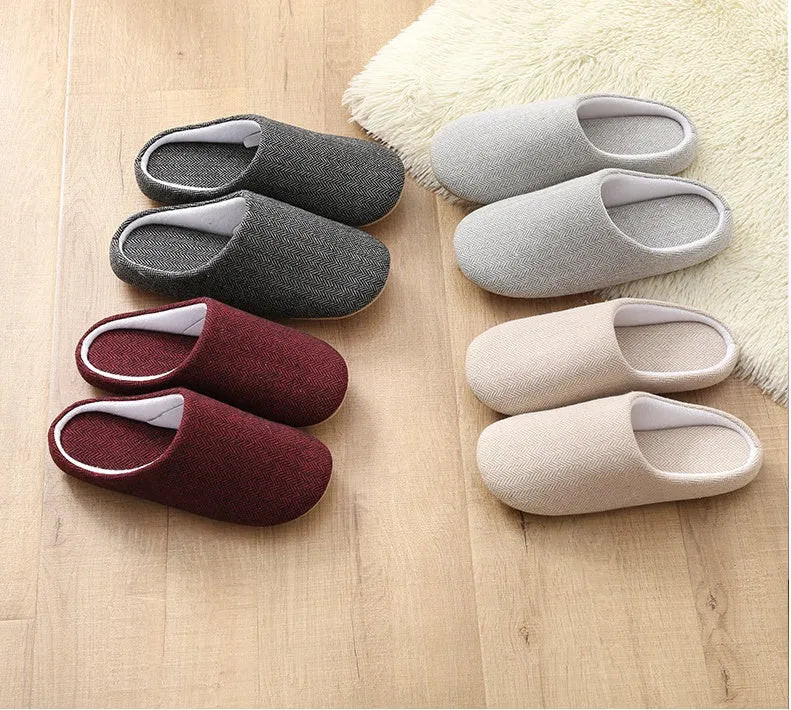 Men's cotton black indoor slippers with anti-skid sole on a home floor