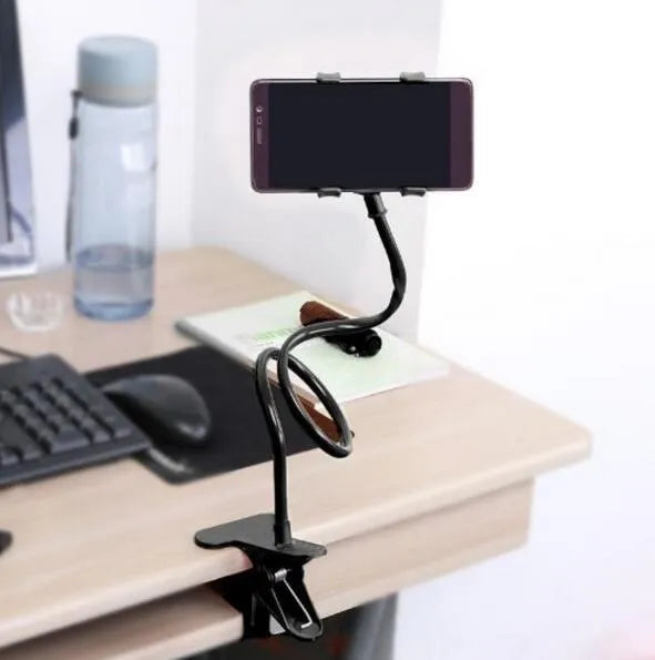 Black portable phone holder with long flexible arm and V-clip mounted on a bed frame.