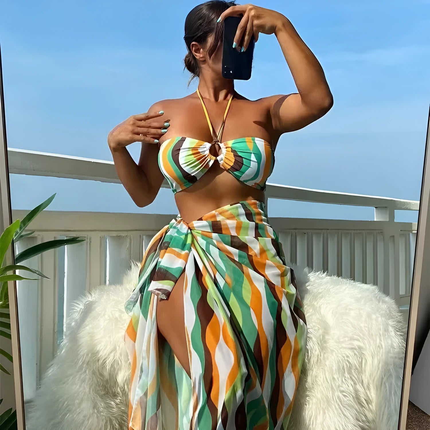 Women's yellow green three-piece bikini set with matching printed beach skirt laid flat.