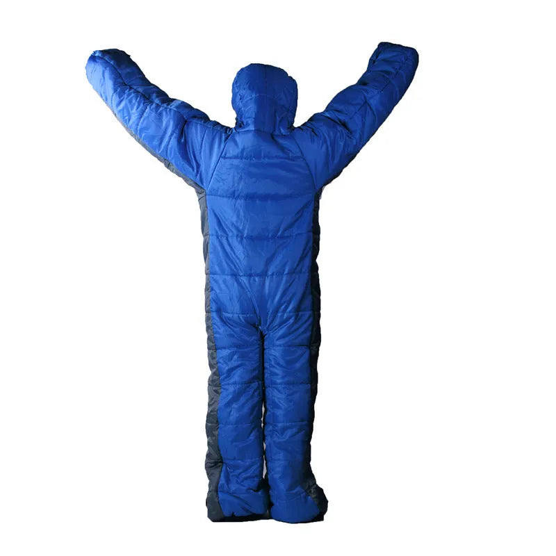 Blue gray patchwork humanoid sleeping bag on grass, legs separated for walking, mummy hood zipped with fill visible.