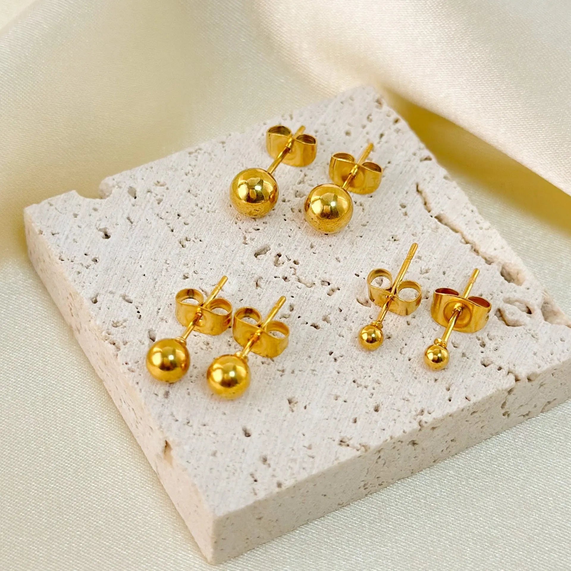 Stainless steel ball stud earrings with geometric round design in gold and silver finishes