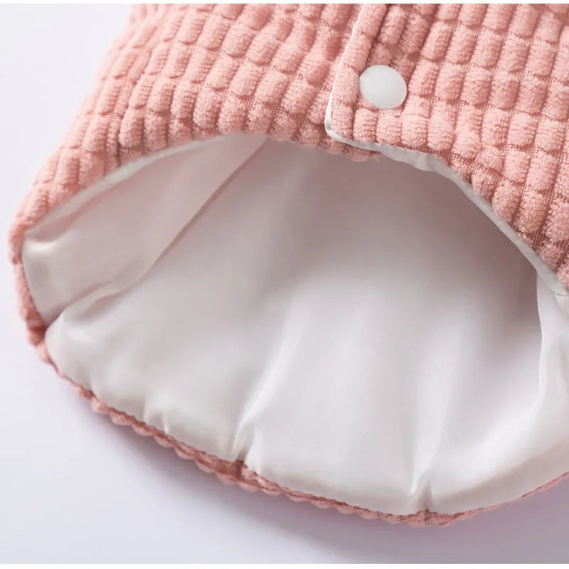 Pink ribbed corduroy dog vest with metal leash ring and bear emblem tag, sizes XS to XXL.