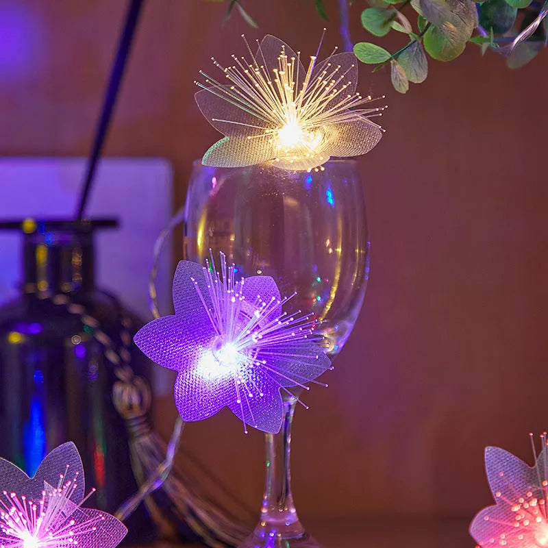 LED optical fibre flower light string with 20 warm white flower-shaped beads on a dark background