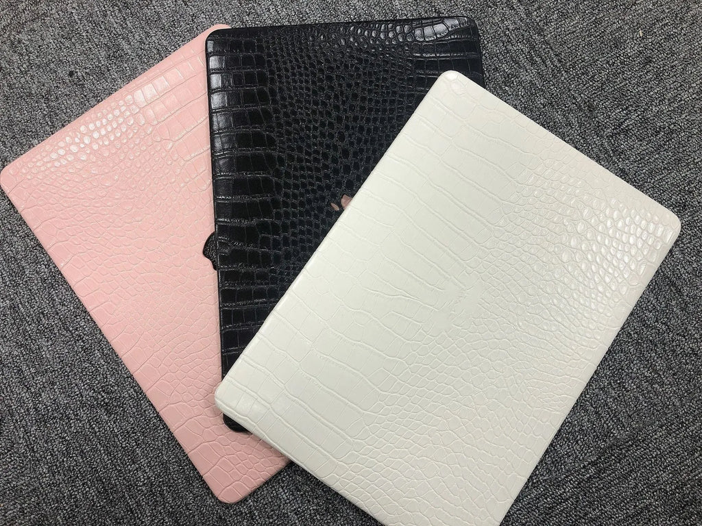 MacBook laptop case with crocodile pattern texture in black, white, or soft pink, showing hollowed Apple logo.