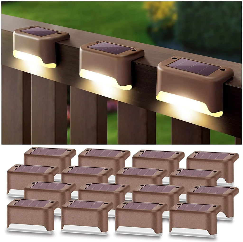 Set of four brown solar step lights with warm LED glow mounted on outdoor wooden stairs