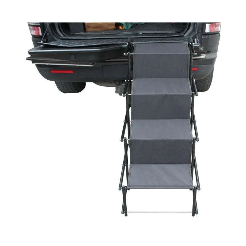 Folding stainless steel pet dog ladder in open position, showing steps, against a car boot.