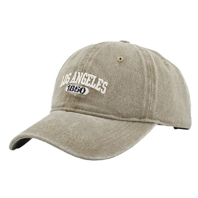 Retro distressed acrylic cap with embroidered letters, shown in beige colour with adjustable strap.
