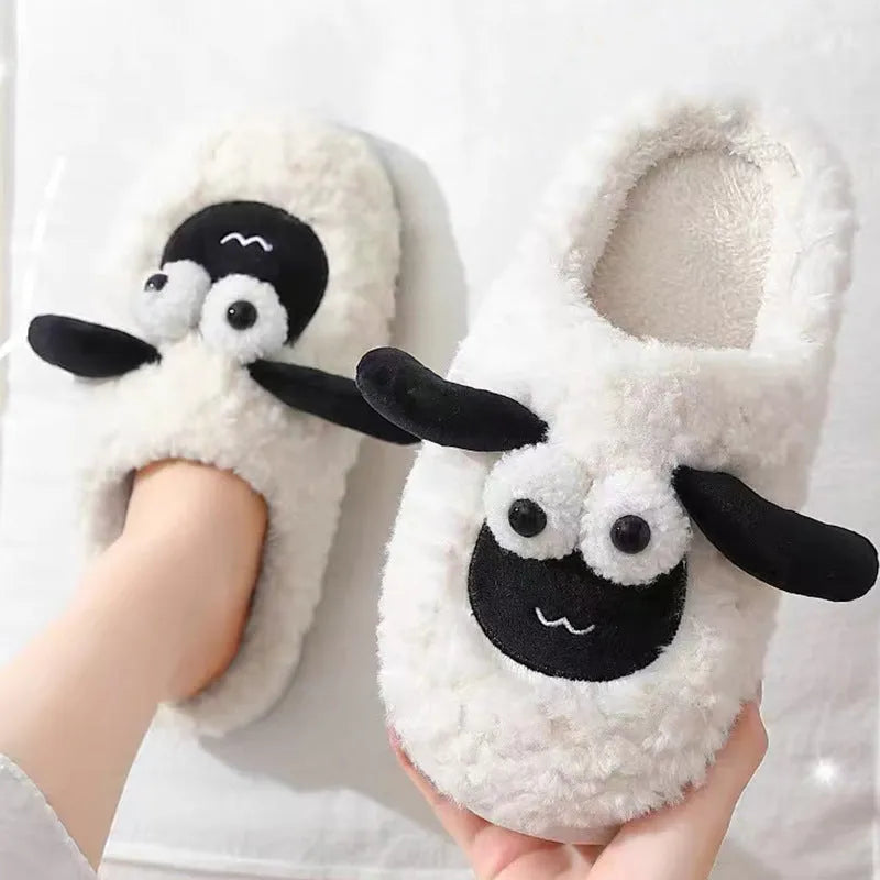 Brown unisex slip-on slippers with suede upper and light sole on a wooden floor.