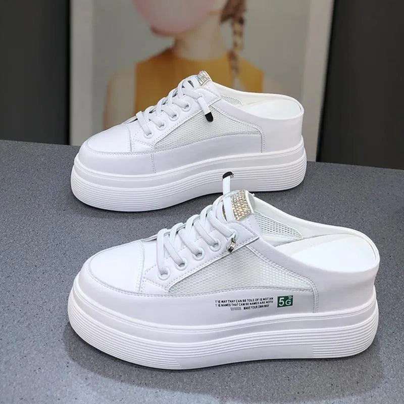 White women's platform trainers with mesh panels and a round toe on a rubber sole.