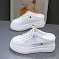 White women's platform trainers with mesh panels and a round toe on a rubber sole.