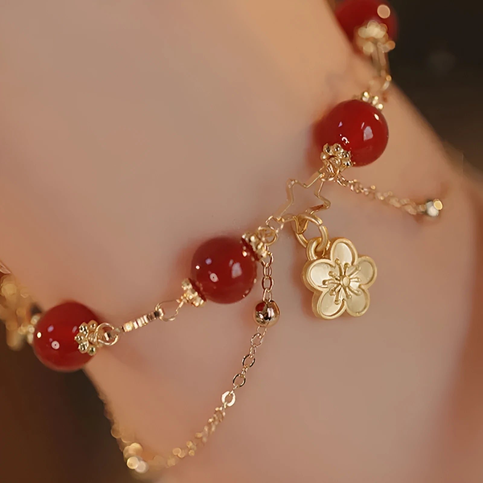 Red agate double layer bracelet with peach blossom floral details on woman's wrist