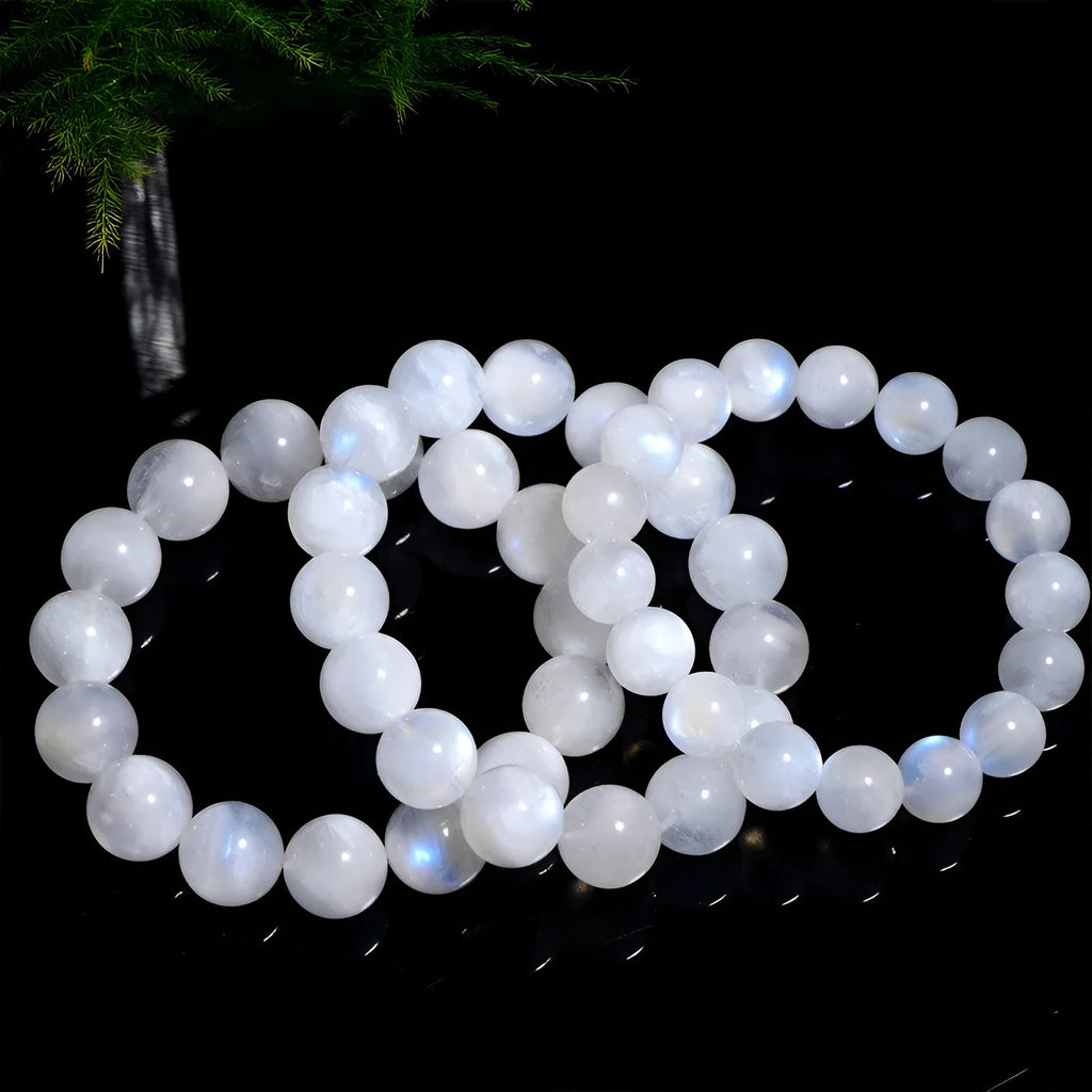 Natural blue moonlight round moonstone bead bracelet on a wrist, showing polished gemstone surface.