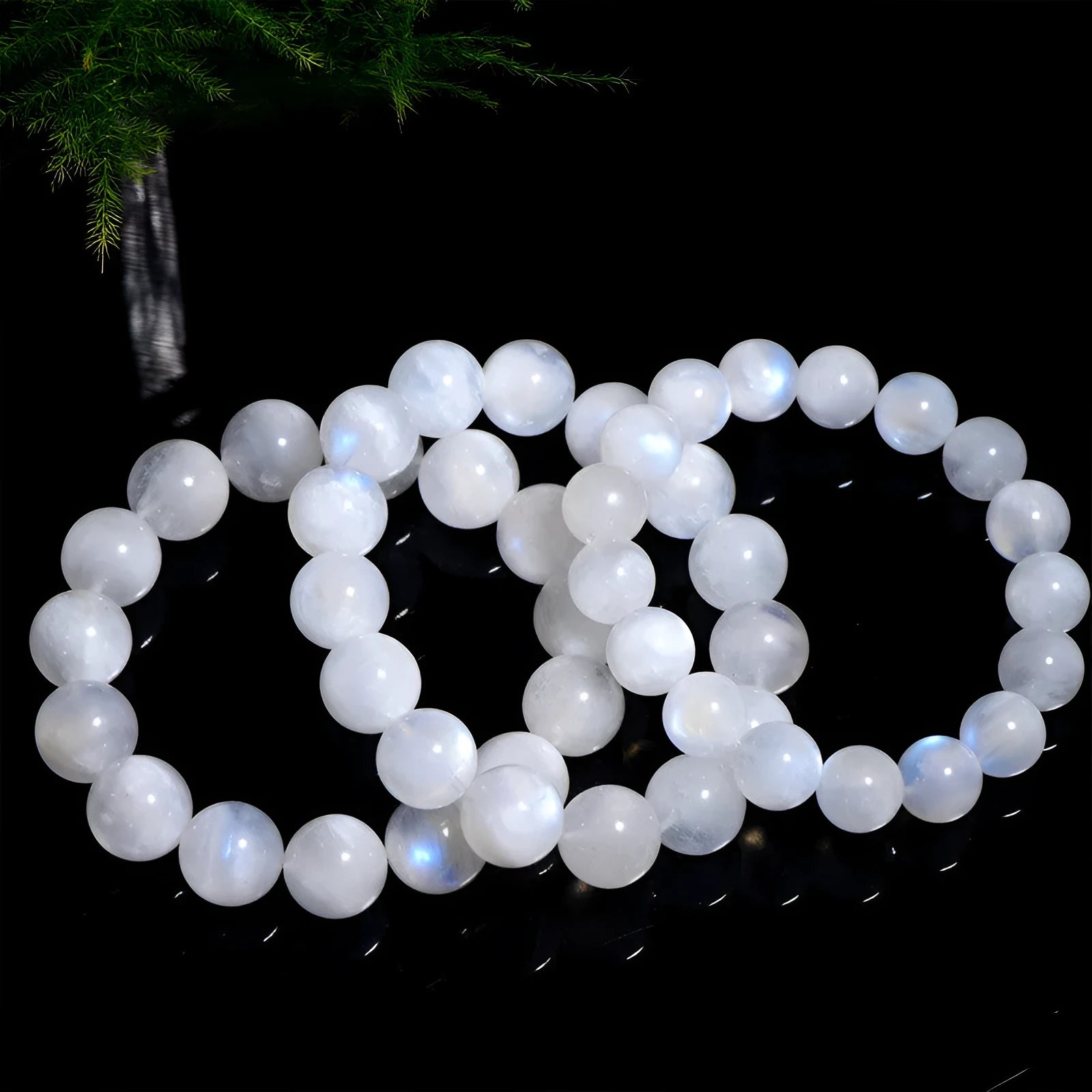 Natural blue moonlight round moonstone bead bracelet on a wrist, showing polished gemstone surface.