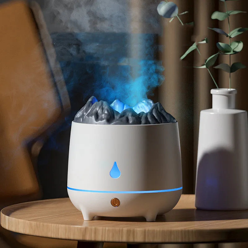White volcano-shaped ultrasonic humidifier with USB cable on table emitting mist
