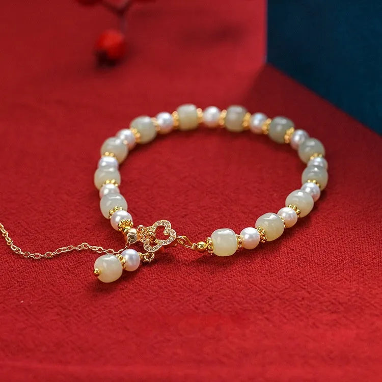 Women's bracelet with a round Hetian jade bead, pearl pendant, and gold-colour alloy clasp.