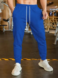 Man wearing beige linen-style loose fit trousers with an elastic drawstring waist.