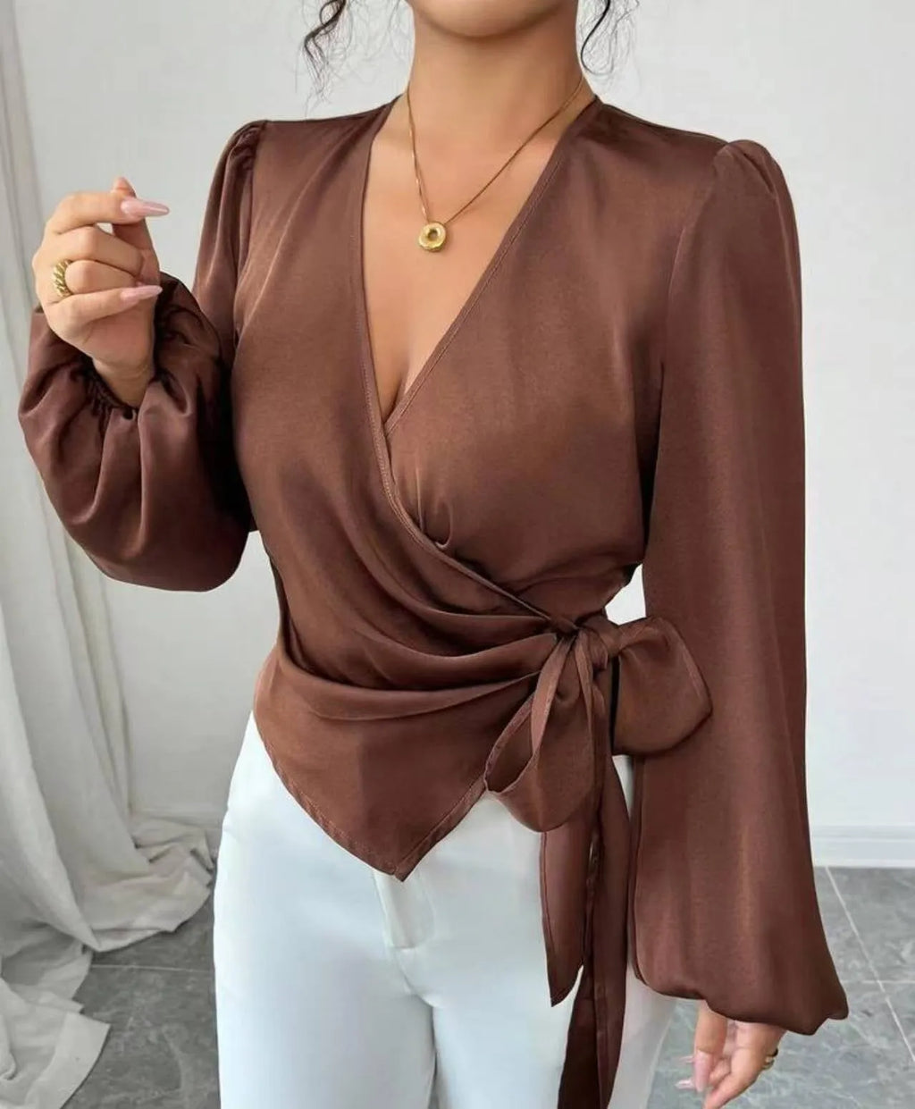 Brown long-sleeved waist-cinching shirt with ribbon detail on a female model