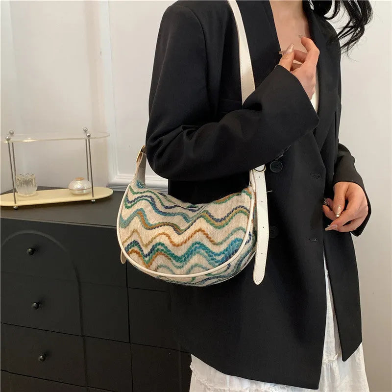 Women's woven straw crossbody bag showing knitted pattern and internal organisation compartments