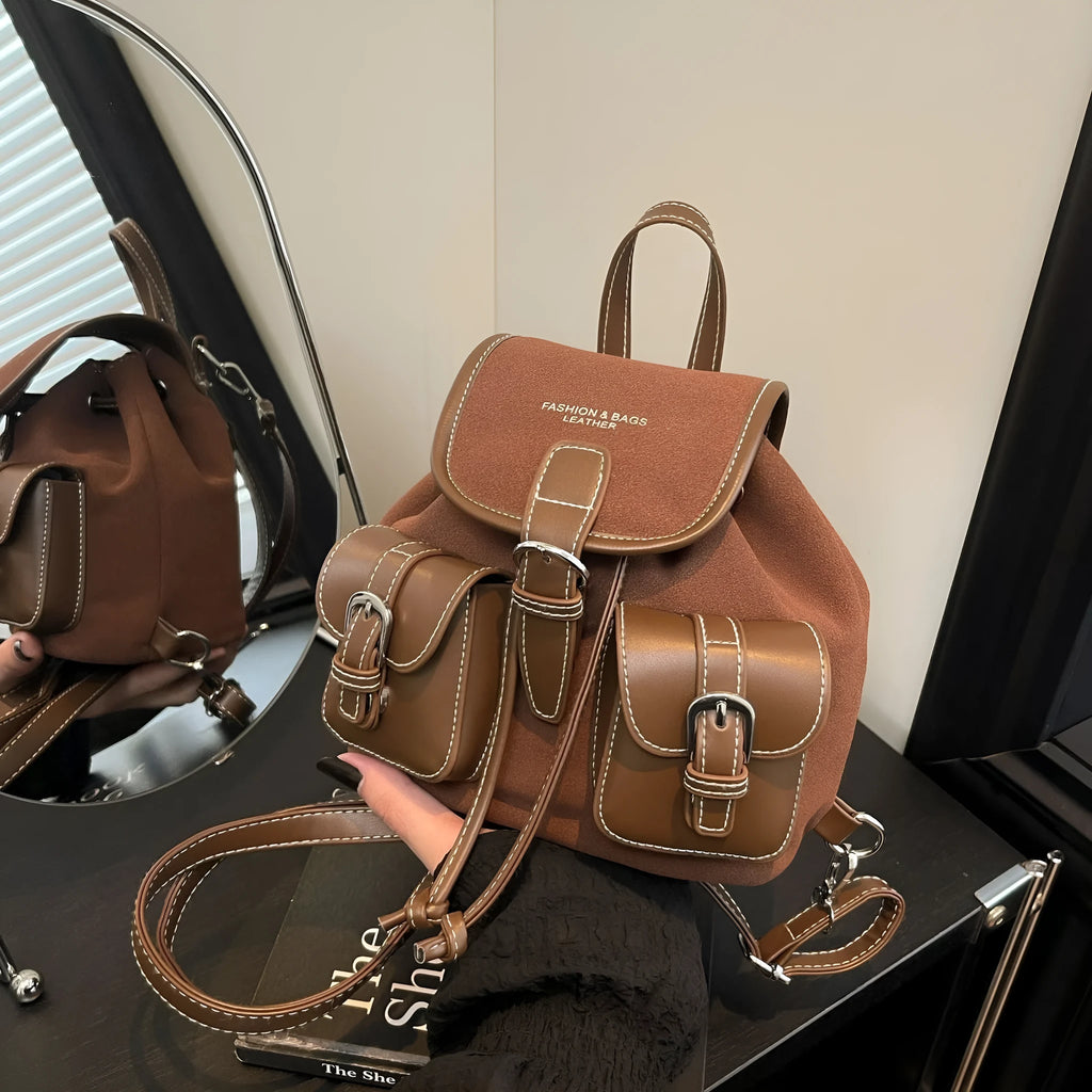 Urban simplicity PU backpack in brown with contrast stitching and clamshell opening, on a flat surface