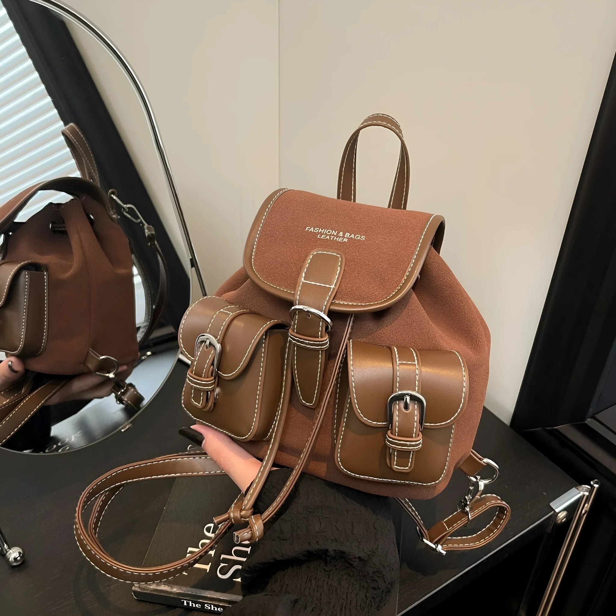 Urban simplicity PU backpack in brown with contrast stitching and clamshell opening, on a flat surface