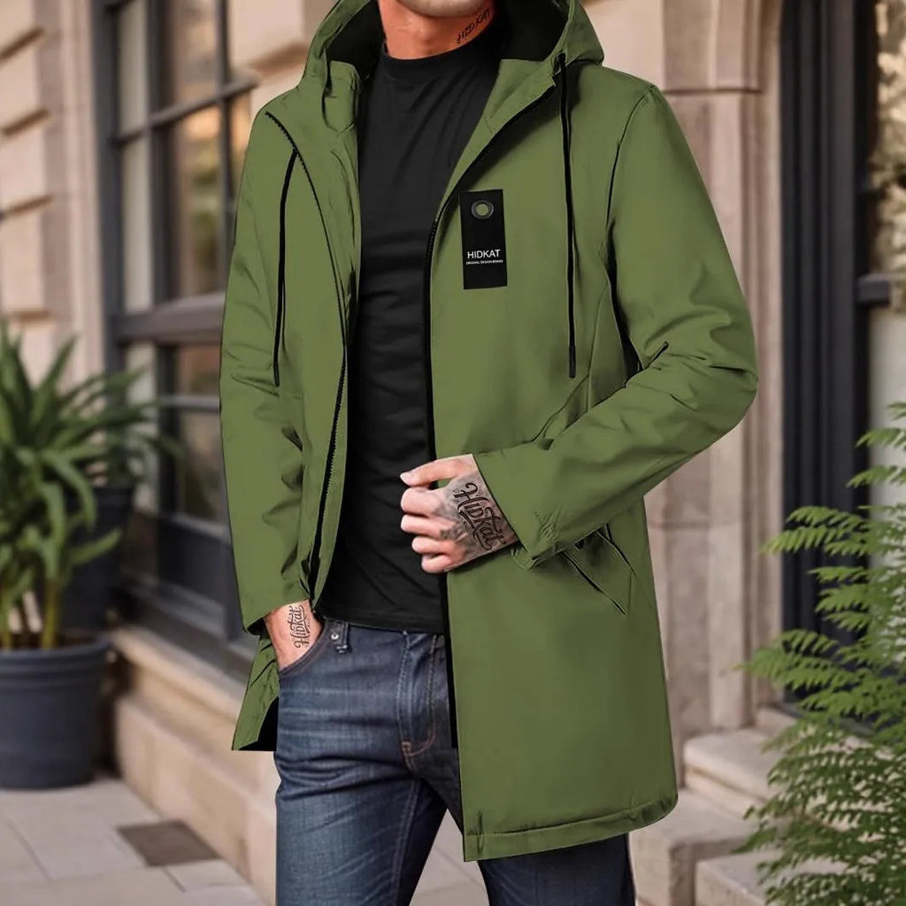 Men's mid-length windproof hooded polyester shell jacket in army green on a model outdoors