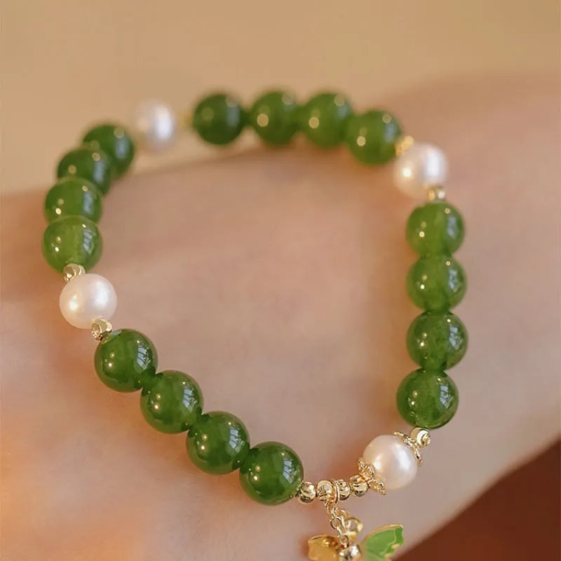 Close-up of a round natural green chalcedony bracelet on a woman's wrist.