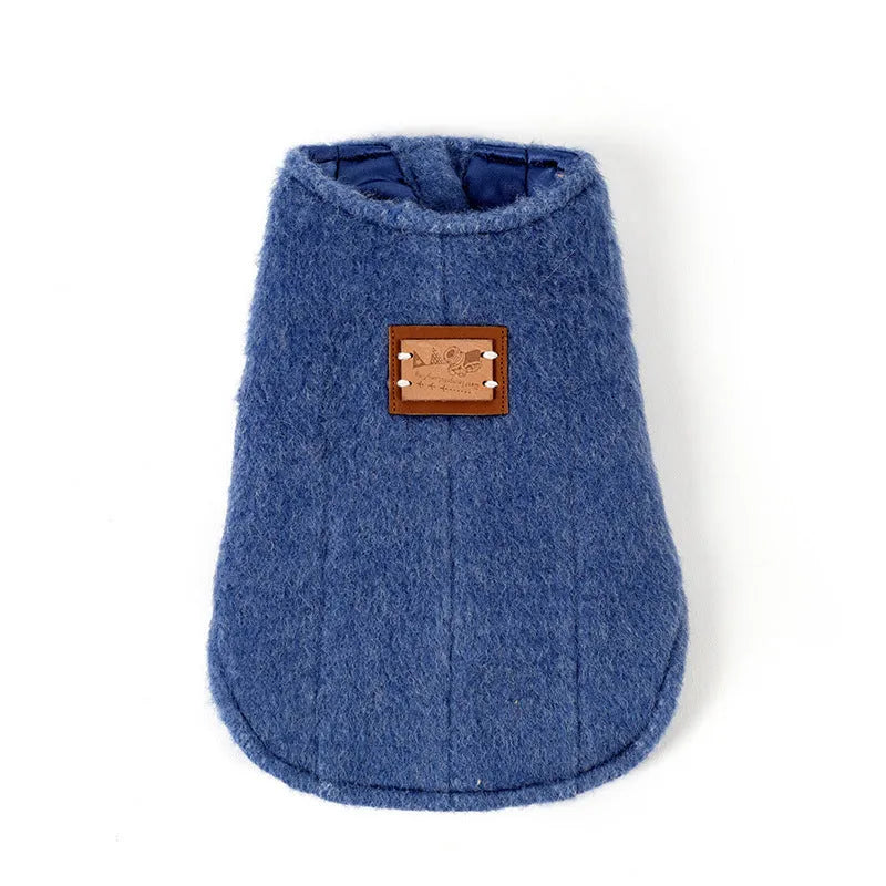 A small dog wearing a blue cotton Korean cashmere vest, a type of casual autumn and winter pet clothing.